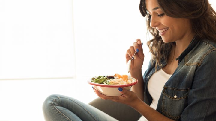 woman eating healthy bowl of oats and others
