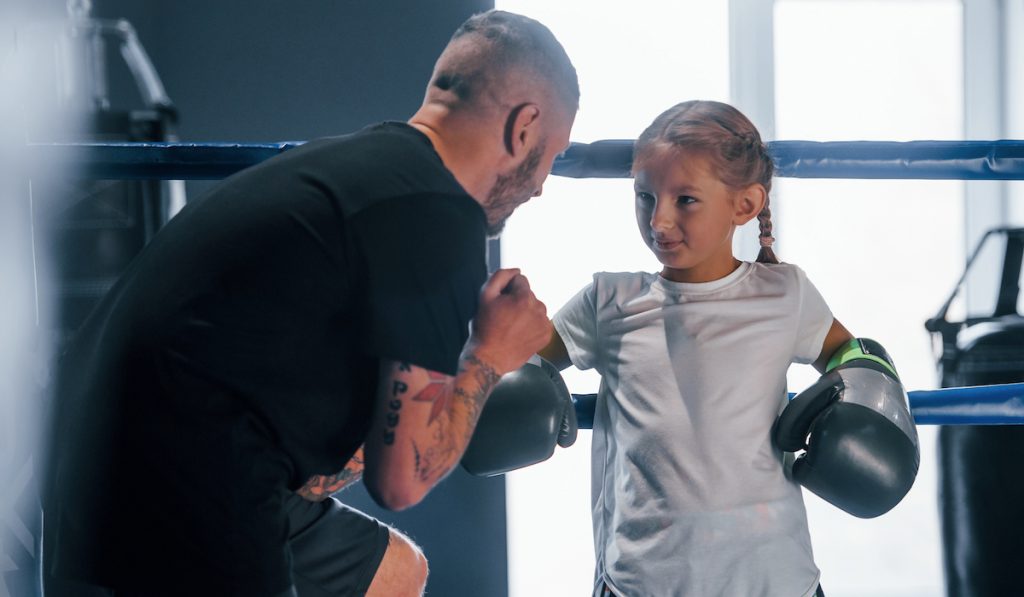 boxing coach teaching a little girl