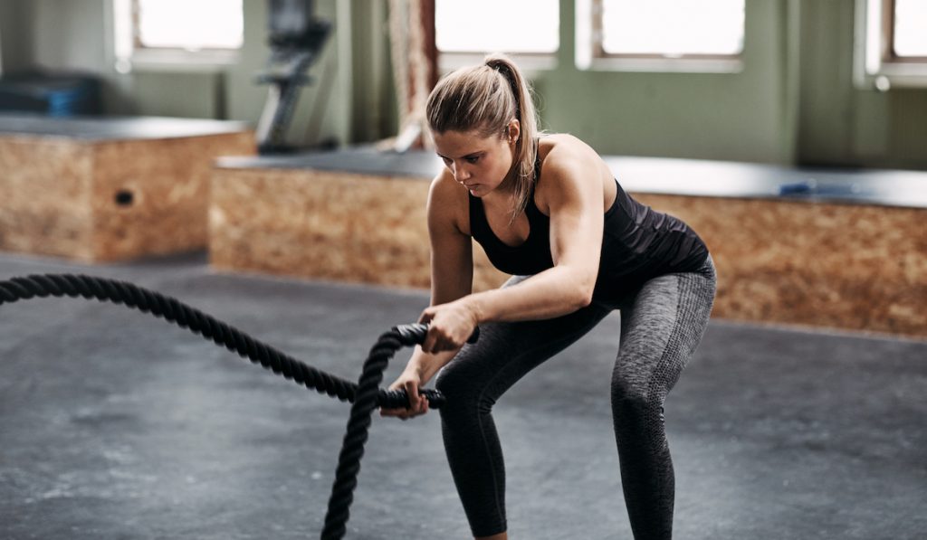 focused woman doing battle rope