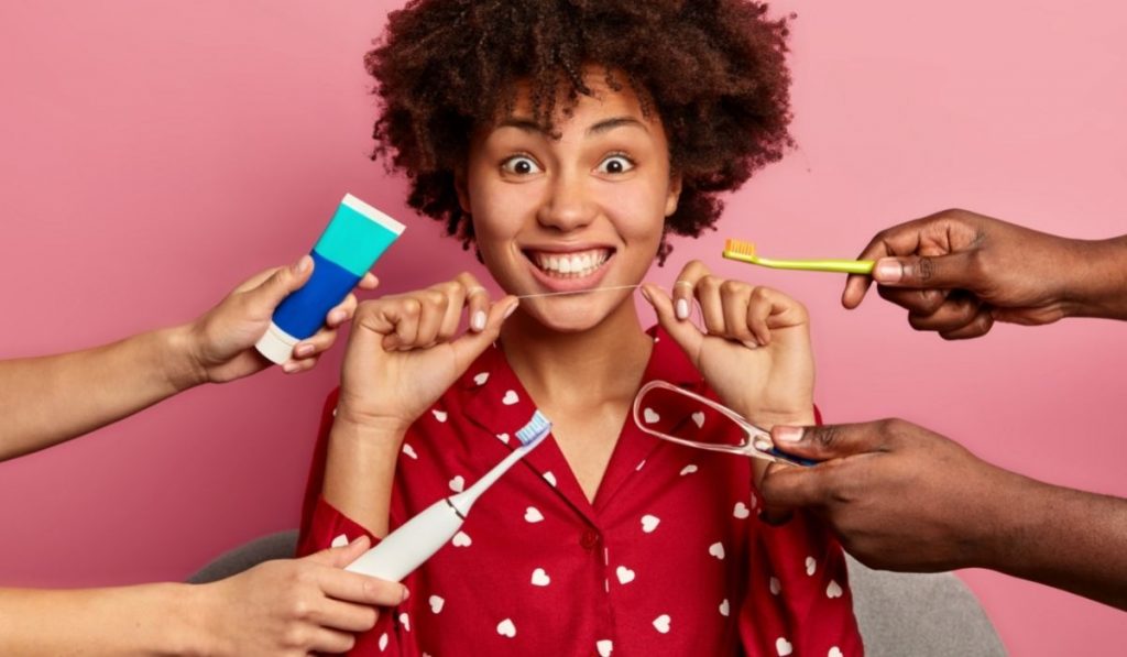 happy curly woman holding a floss, loves to take care of her teeth - 220401