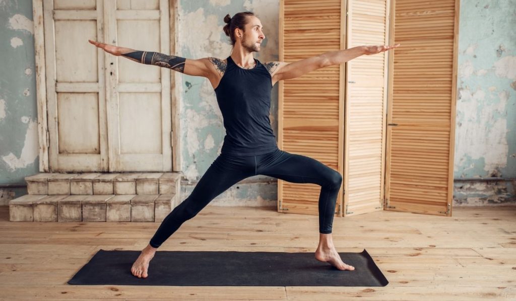 man doing yoga on a yoga mat - ee220319