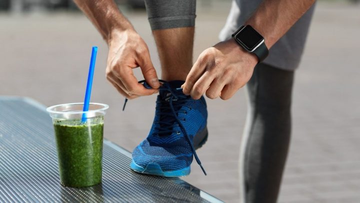 man tying shoelace and a cup of green juice - ss220324