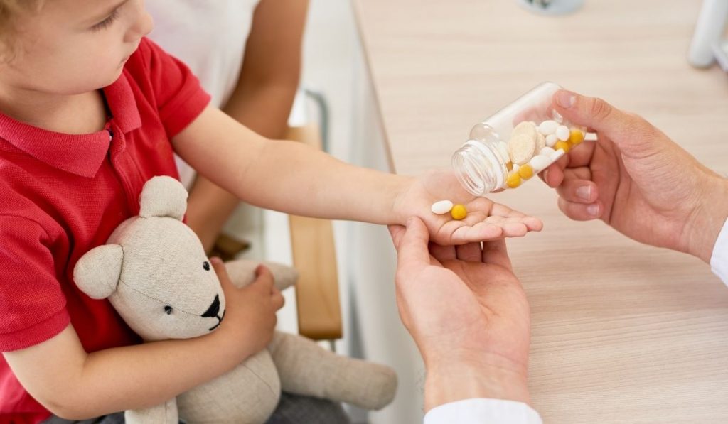 pediatrician giving vitamins to a child - ee220321