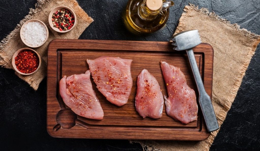 turkey meat with spices and herbs on the chopping board