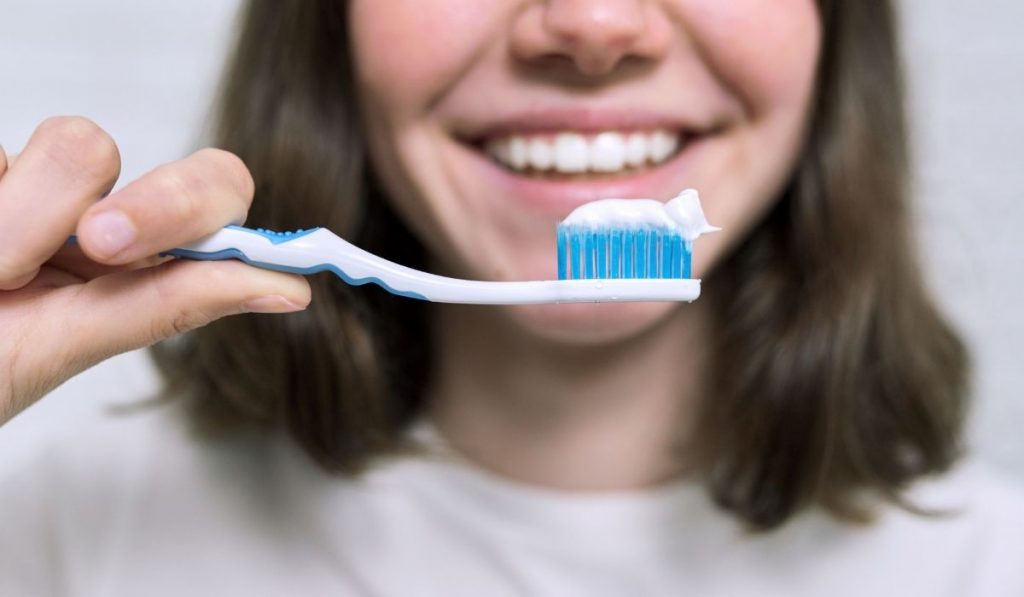 woman holding a toothbrush with toothpaste - ee220401