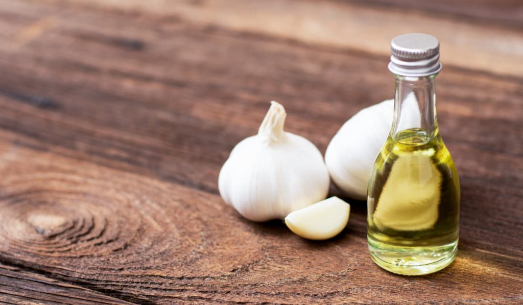 two gloves of garlic and small bottle of oil